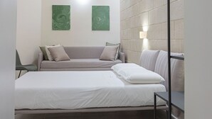 Un dormitorio moderno con una cama, un sofá y una estantería en la pared.