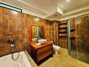 Een moderne badkamer met een bad, een grote spiegel, een wastafel en een douchecabine.