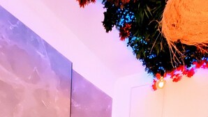 A modern bathroom with a large bathtub, a hand-shaped decoration, and a ladder against the wall. - Kosykasa Spa (Cannes)
