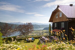 Une maison en bois avec vue sur un lac et des montagnes.