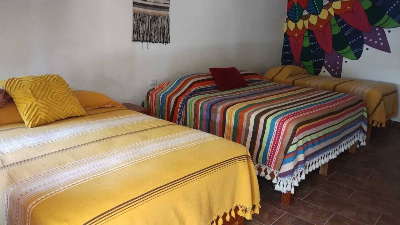 A room with two beds, each with a distinct patterned bedspread.