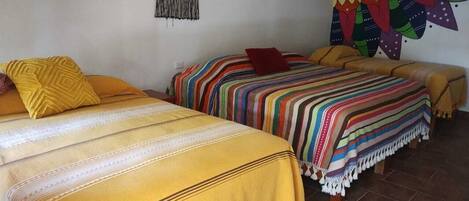 A room with two beds, each with a distinct patterned bedspread.