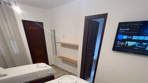 A hotel room with two beds, a TV mounted on the wall, and a wooden floor. - Pousada Terra das Águas Barreirinhas (Barreirinhas)