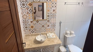 A bathroom with a tiled backsplash, a sink, a toilet, and a towel rack. - Pousada Terra das Águas Barreirinhas (Barreirinhas)
