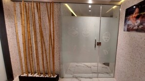 A modern reception area with a glass door, a bamboo decoration, and a framed picture on the wall. - Hotel Atlantis Alger (Algiers)