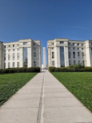 A symmetrical building complex with a central pathway leading to a tall structure.