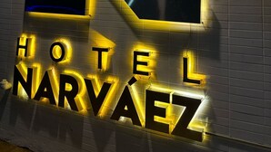 Letrero de hotel con una 'N' grande iluminada y el nombre 'HOTEL NARVAEZ' en letras negritas.