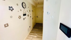 A hallway with a clock, a sign reading "HOME", and a door at the end. - London Bridge: Private Rooftop Terrace 3BR-7Guests (London)