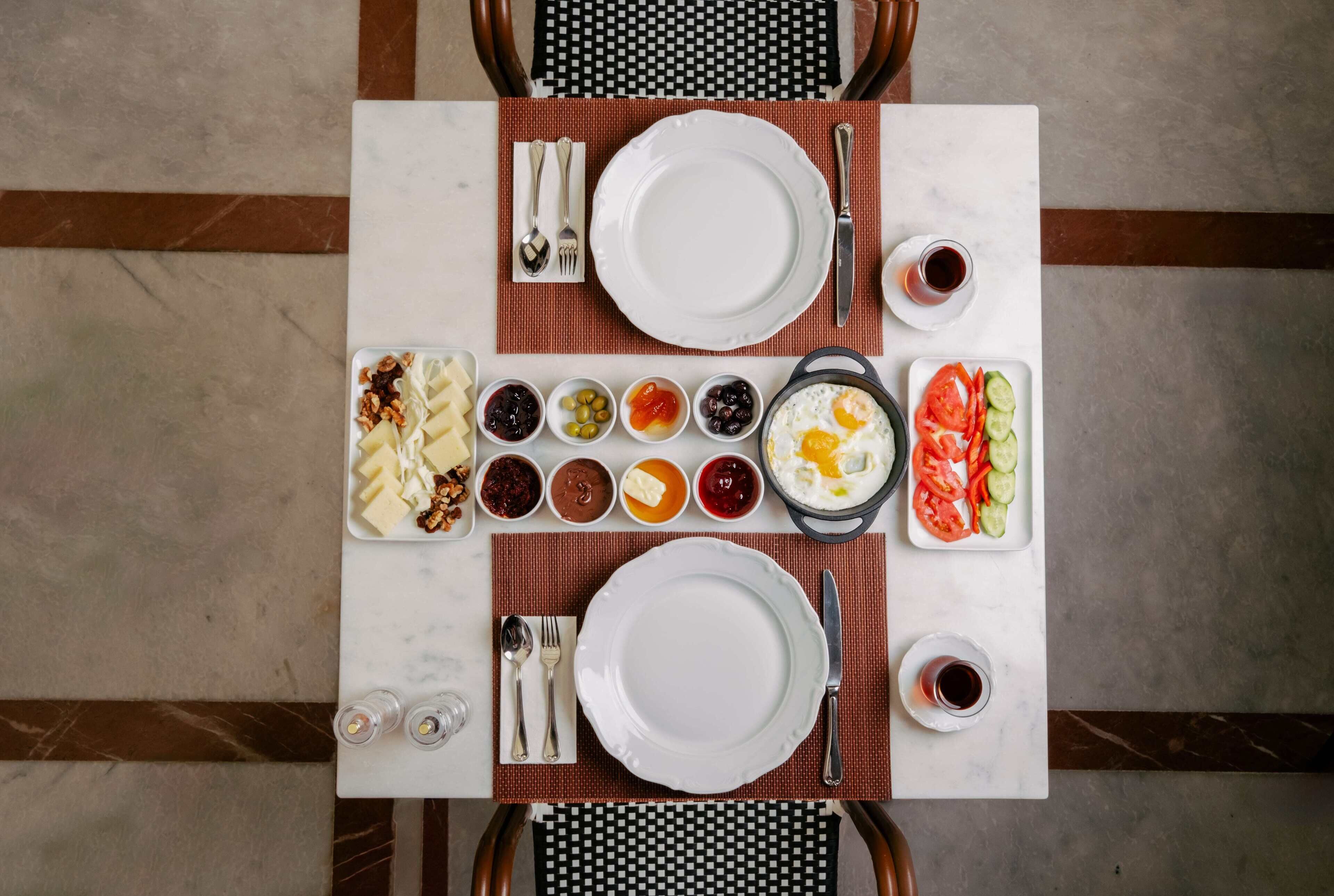 Una mesa servida con platos, tazones y cubiertos, dispuesta para una comida.