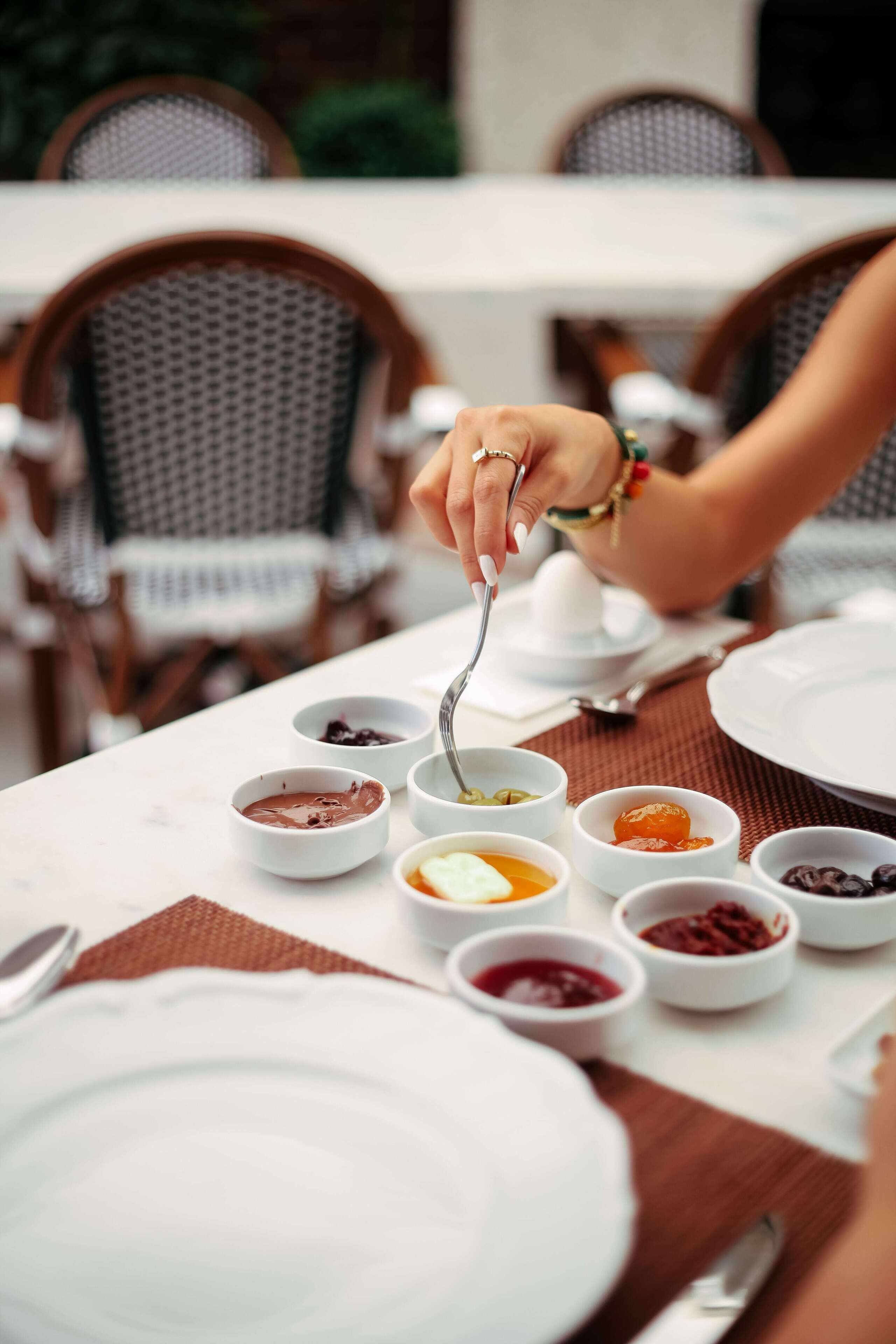 Uma mesa de jantar com diversos pratos e uma pessoa a comer.