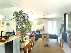 A spacious living area with a dining table, chairs, a large potted plant, a sofa, and a ceiling fan. - La Méridienne - Lorgues (LORGUES)