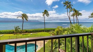 A poolside view with a clear view of the ocean and palm trees. - Oceanfront, King Bed, Split AC, WiFi, Hot Tub Pool (Wailuku)