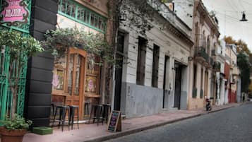 Una calle con edificios, un cartel de café y una motocicleta estacionada al costado.