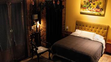 Una habitación con una cama, una silla, un cuadro y una puerta.