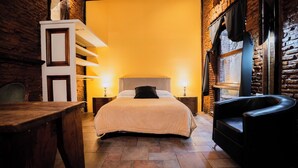 A cozy room with a bed, a chair, and a table. - Hotel Pasaje Solar (Buenos Aires)