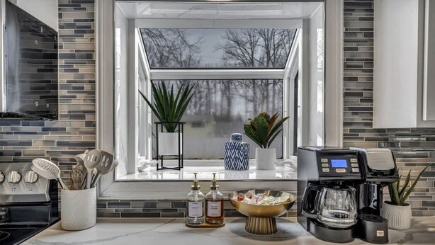 A modern kitchen with a large window, a coffee maker, and various kitchen utensils. - Pool - Hot Tub - Game Room - Sleeps 8 (Ashtabula)