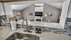 A modern kitchen with a large sink, white countertops, a built-in stove, and a ceiling fan. - Pool - Hot Tub - Game Room - Sleeps 8 (Ashtabula)
