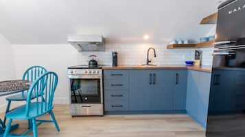 Een oven, een kookplaat, kookgerei, borden en bestek