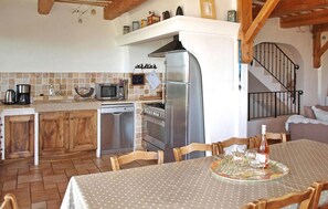 Enjoy meals in the well-equipped kitchen with microwave, oven, and dishwasher, adjacent to a dining area with seating for four.