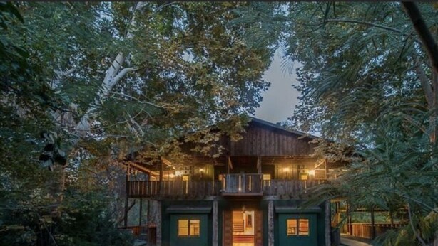 A rustic cabin with a wooden exterior, a central entrance, and a porch area. - Spacious 5-bedroom Lodge nestled at the Gateway to the Sequoias.  (Three Rivers)
