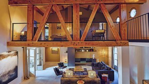 A spacious loft with exposed wooden beams, a high ceiling, and a mezzanine level. - Awesome home in Saint Siffret with WiFi (Saint Siffret)