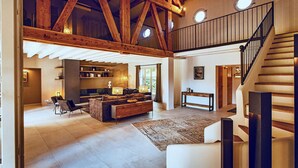 A spacious living area with exposed wooden beams, a staircase, and a view of the outdoors. - Awesome home in Saint Siffret with WiFi (Saint Siffret)