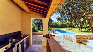 A covered outdoor kitchen with a pool and lounge area. - Awesome home in Saint Siffret with WiFi (Saint Siffret)
