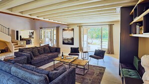 A spacious living room with a high ceiling, a sofa set, a coffee table, and a bookshelf. - Awesome home in Saint Siffret with WiFi (Saint Siffret)