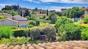 A residential area with houses, a church, and a garden with a water feature. - Les Murmures Du Ventoux (Mormoiron)