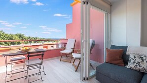 Ein Balkon mit Tisch, Stühlen und einer Couch.