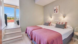Ein Schlafzimmer mit zwei Betten, einer Treppe und einem Balkon mit Blick.