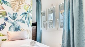 A bedroom with a bed, a window, and curtains.