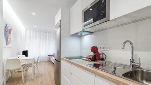 A modern kitchen with white cabinets, a stainless steel sink, and a built-in microwave.