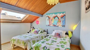 Ein Schlafzimmer mit zwei Betten, einem Oberlicht, einem Gemälde und einem Schild mit der Aufschrift 'Zen'.