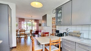 Eine Küche mit Essbereich, inklusive Tisch, Stühlen und einem Kühlschrank.