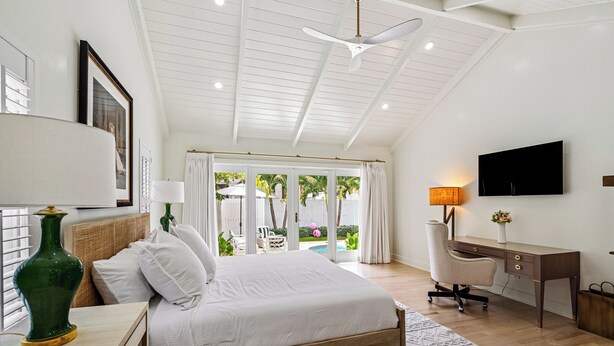 Une chambre à coucher avec un lit, un bureau, une chaise et un téléviseur.