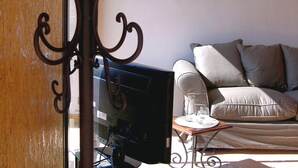 A living room with a sofa, a coffee table, and a television.