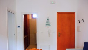 Habitació amb porta de fusta, un telèfon i un radiador.