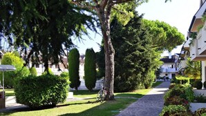 Un carrer residencial amb vorera arbrat, una bicicleta i cases amb balcons.