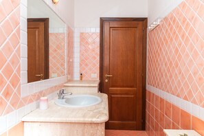 Un bagno con lavandino, specchio e porta in legno.