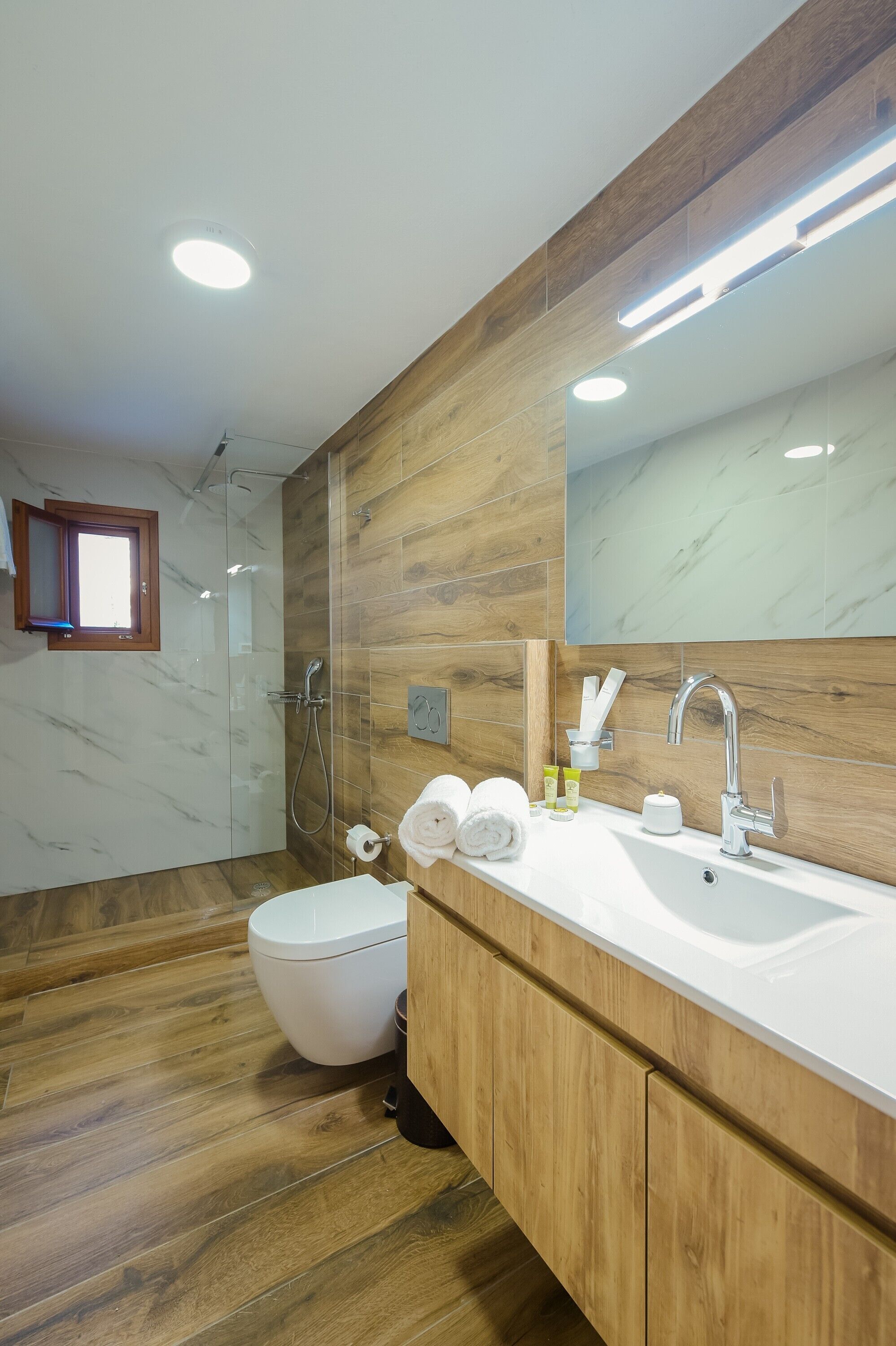 Une salle de bain moderne équipée d’une douche, de toilettes et d’un meuble-lavabo.