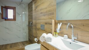 Un baño moderno con ducha, inodoro y tocador.