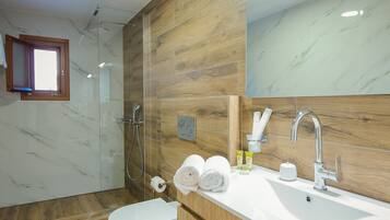 Une salle de bain moderne équipée d’une douche, de toilettes et d’un meuble-lavabo.
