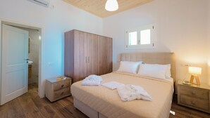 Un dormitorio con cama, mesitas de noche, armario, ventana y aire acondicionado.