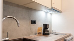 Une cuisine équipée d’un évier, d’une machine à café et d’un paquet de filtres à café.