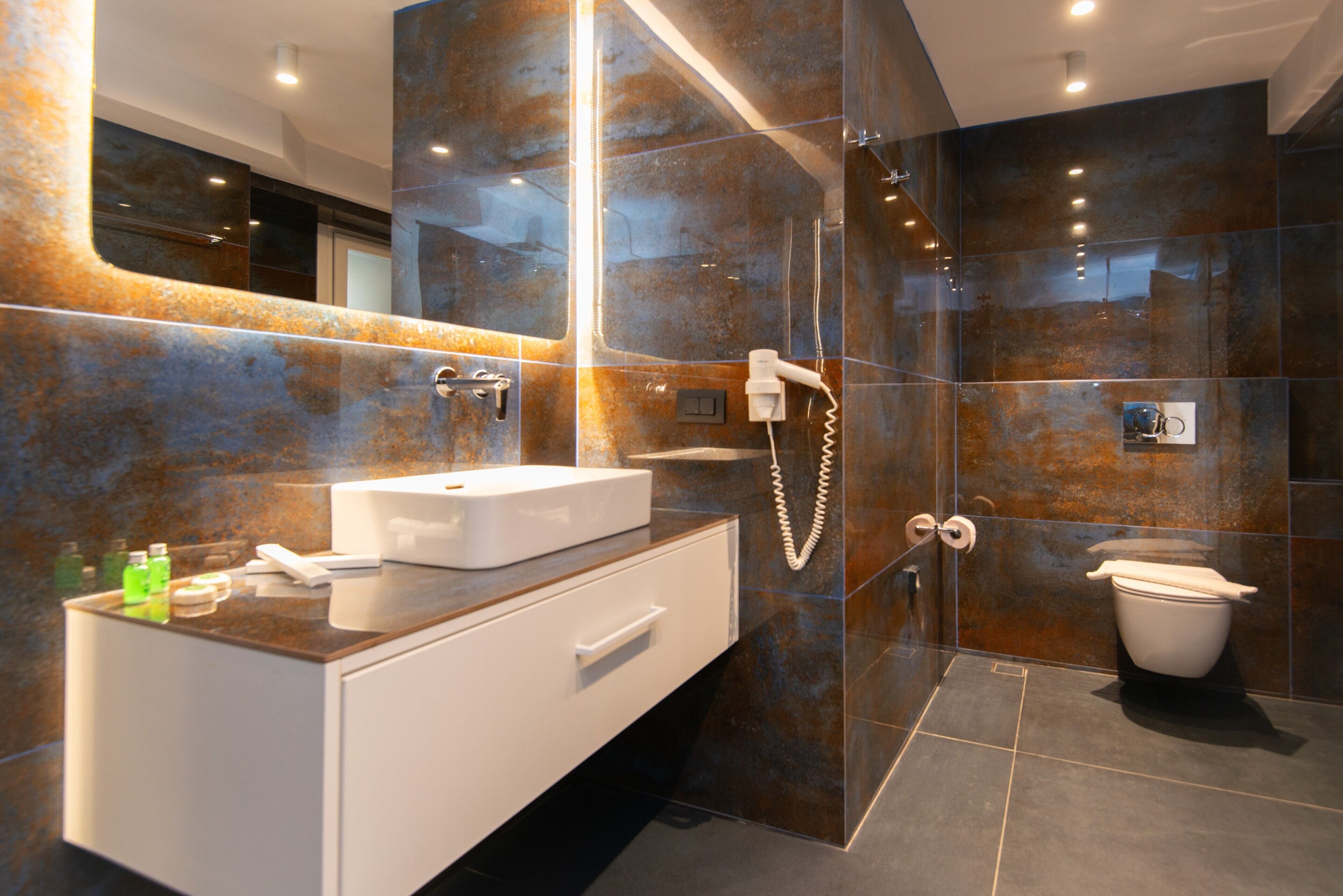 Une salle de bain moderne avec une douche à parois de verre, un lavabo blanc et des toilettes.