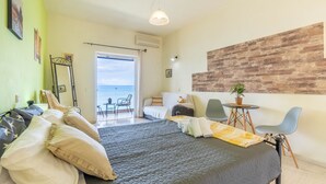 A bedroom with a bed, a desk, a chair, and a view of the sea. - Studio Apartment 'Nikos Seaside  4' with Sea View, Wi-Fi and Air Conditioning (??????a)