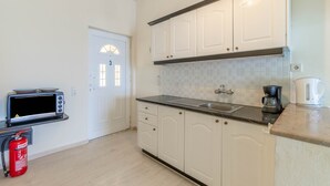 A kitchen with white cabinets, a microwave, a coffee maker, and a fire extinguisher. - Studio Apartment 'Nikos Seaside  5' with Sea View, Wi-Fi and Air Conditioning (??????a)