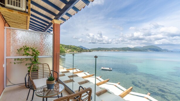 A balcony with a table, chairs, and a potted plant. - Studio Apartment 'Nikos Seaside  5' with Sea View, Wi-Fi and Air Conditioning (??????a)