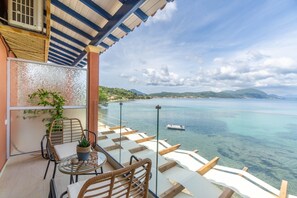 Un balcon avec une table, des chaises et un pot de fleurs.